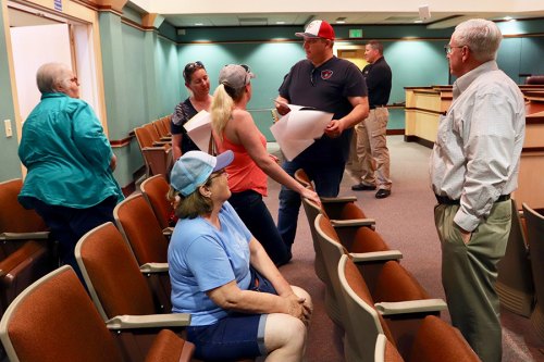 Councilmembers, Stuart Lyons and Dave Brown, meet with constituents following Thursday's special meeting during which the city approved a court-sponsored agreement with Holly Blair.